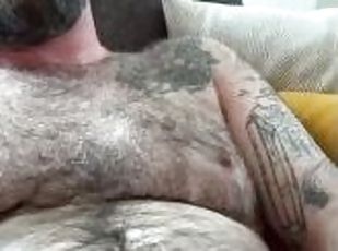 Hairy dad sits back and strokes on the couch, grunting, teasing and edging out a big load
